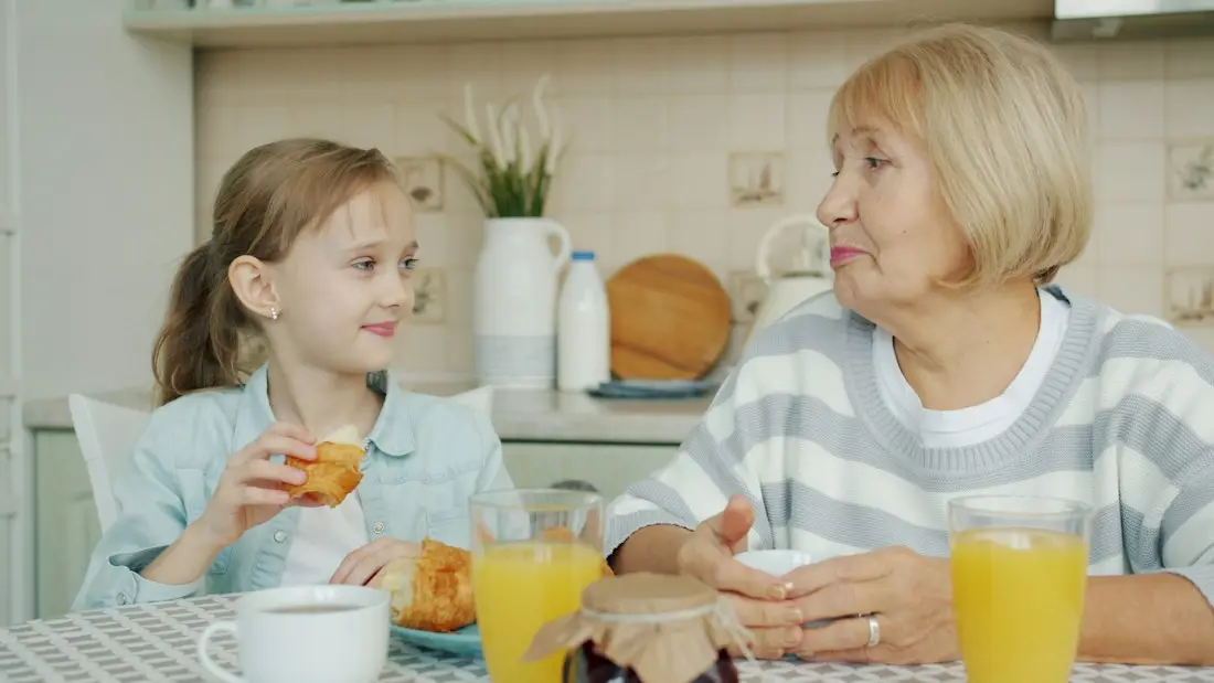 Abuela y nieta desayunando juntas en la cocina
