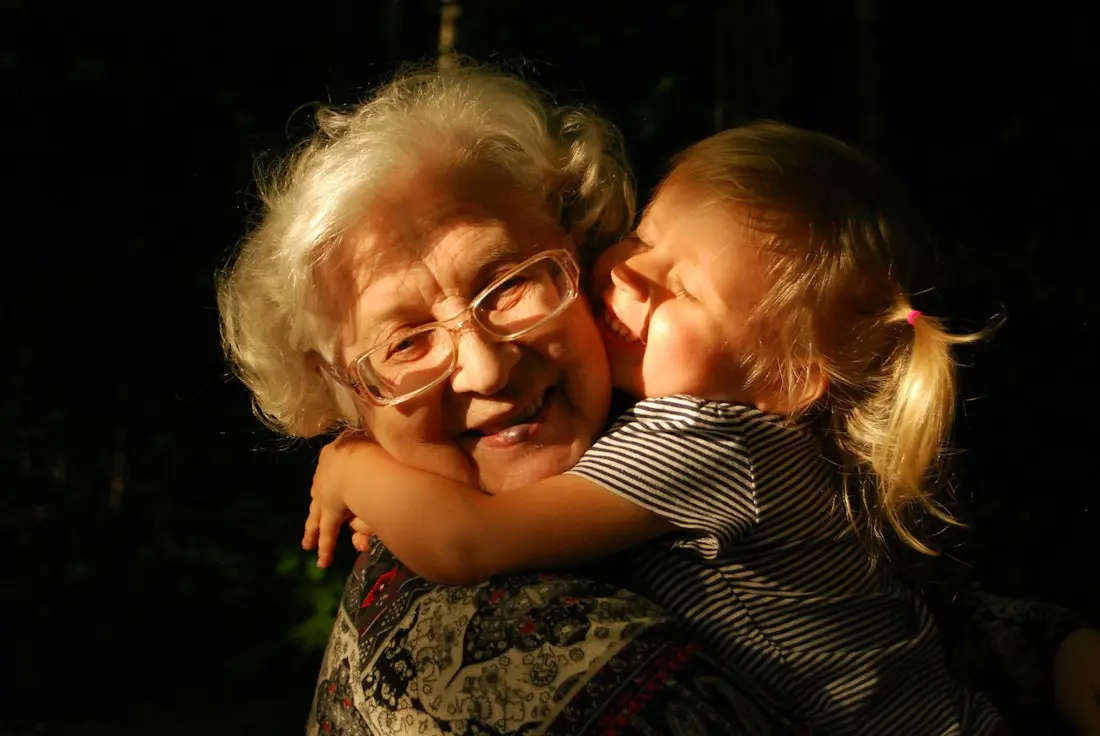 Abuela abrazando a su nieta con una gran sonrisa