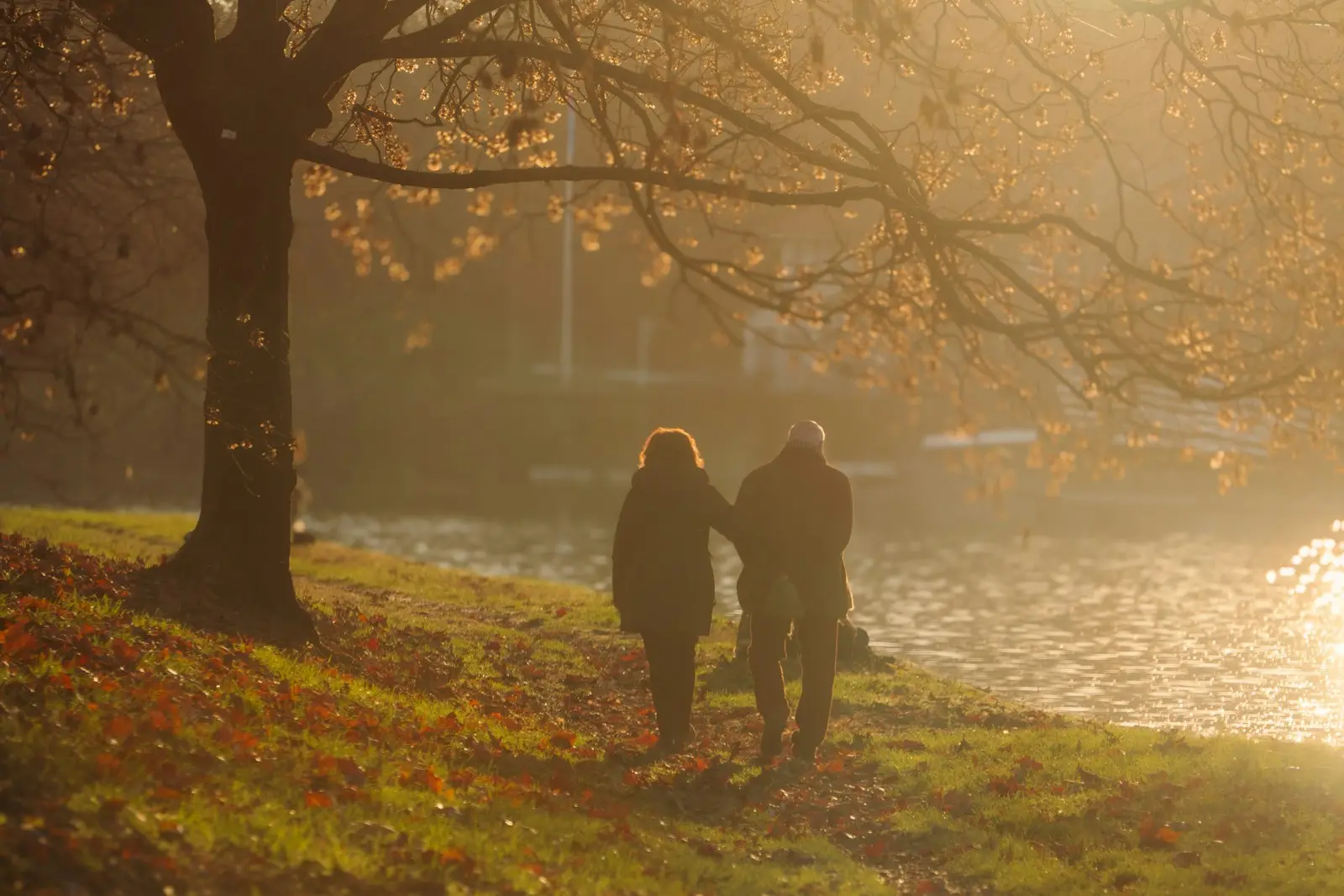 Pareja paseando junto a un río al atardecer